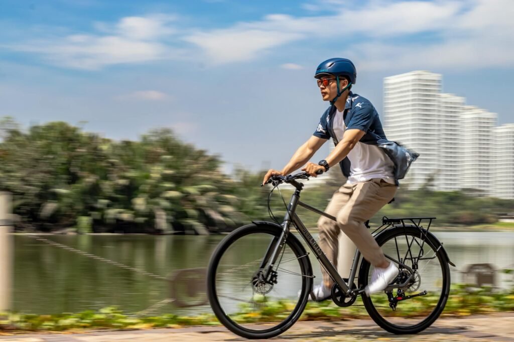 A commuter bike with a helmet, small USB lights, and a reflective strap arranged neatly on the floor