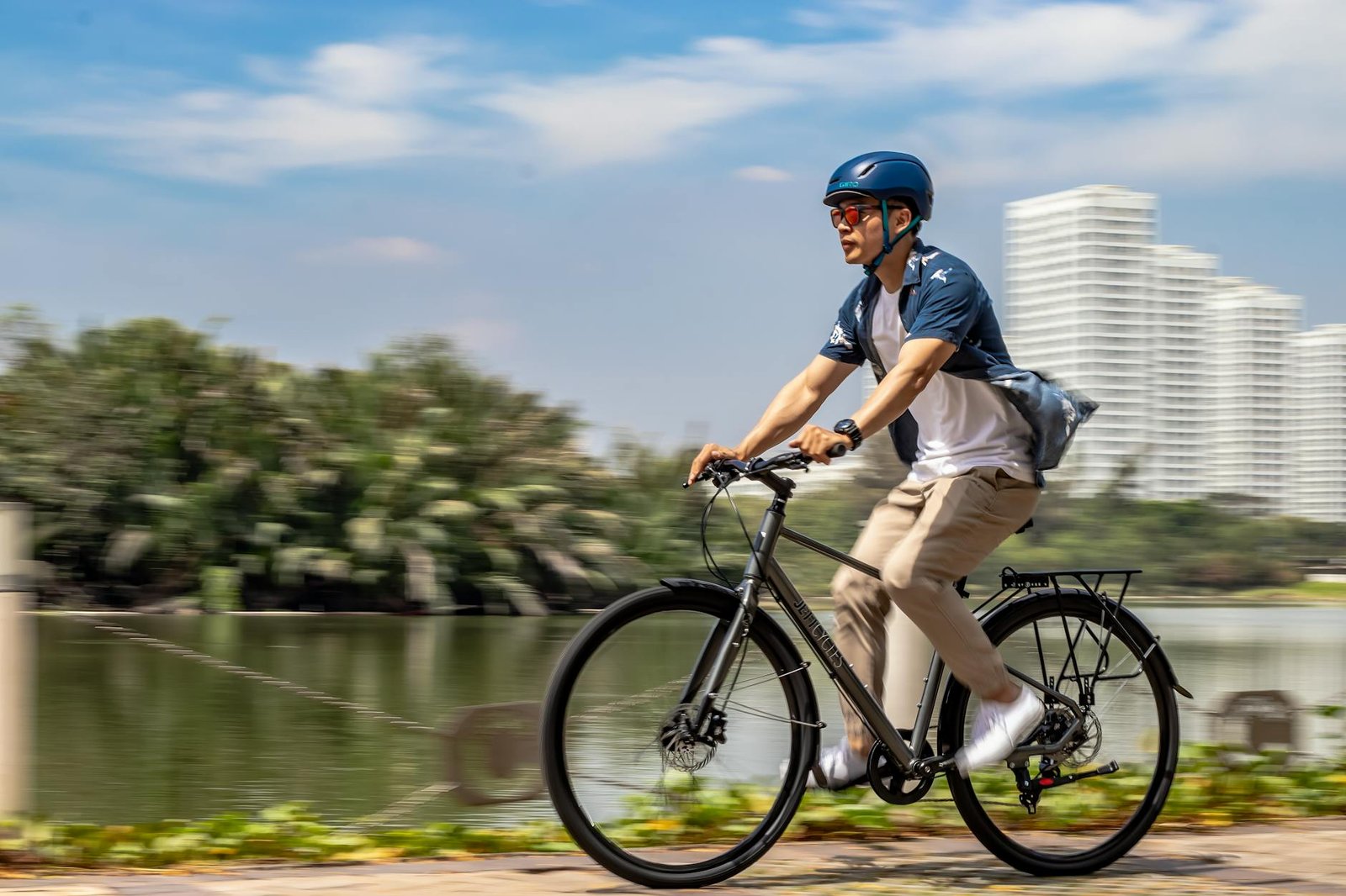 A commuter bike with a helmet, small USB lights, and a reflective strap arranged neatly on the floor
