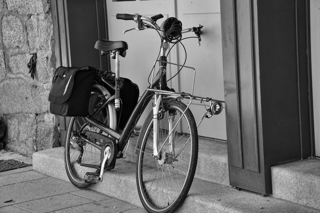 A city commuter bike with a rear rack, pannier, helmet, and floor pump ready for a short ride