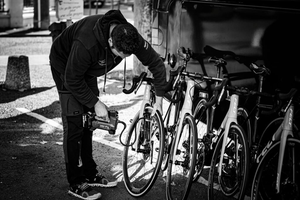 A rider checks tire pressure with a floor pump gauge on a city bike.