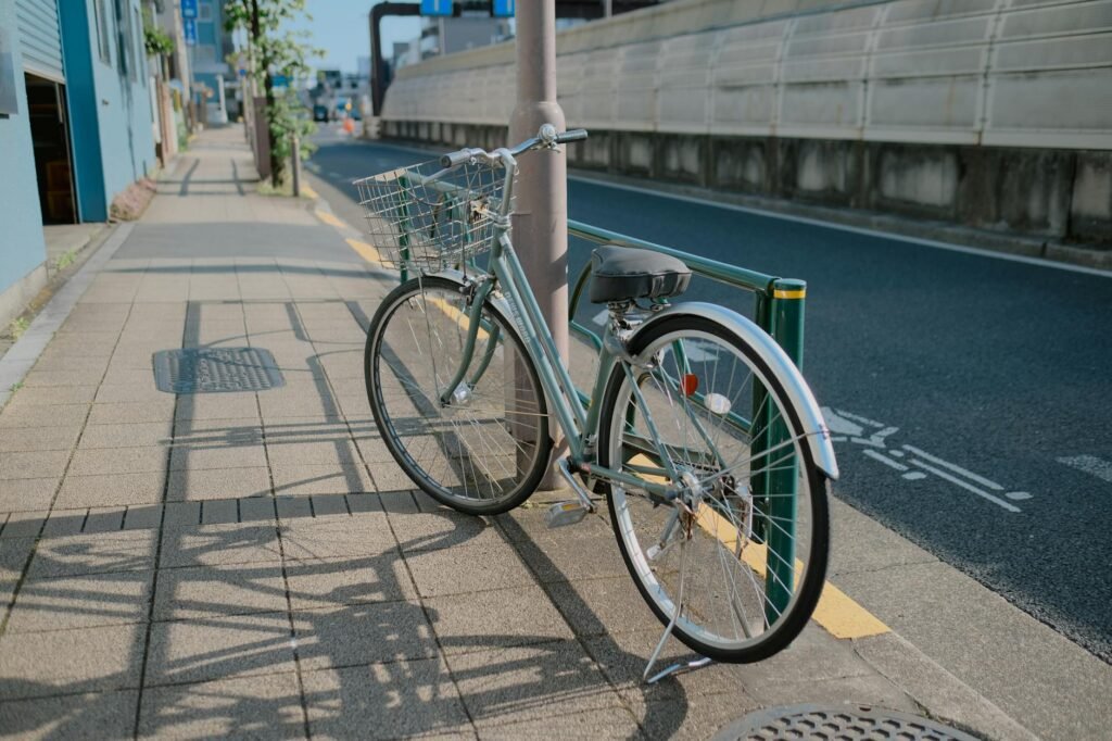 A bicycle parked beside a protected bike lane separated from traffic