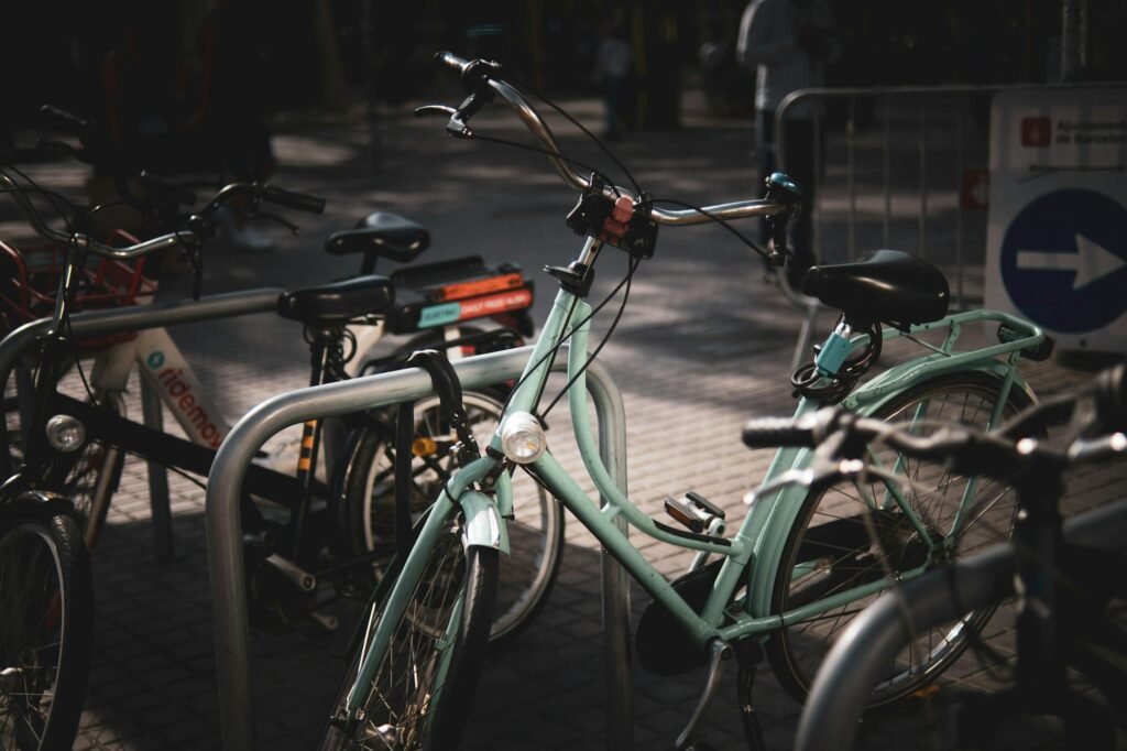 Close-up of a front bike wheel secured with a secondary lock at a public rack