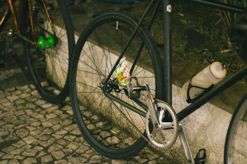 Hands wipe and lubricate a bicycle chain in a tidy home workspace.