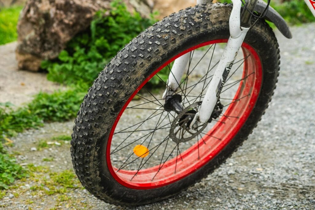 A close-up of a commuter bike tire rolling over rough city pavement