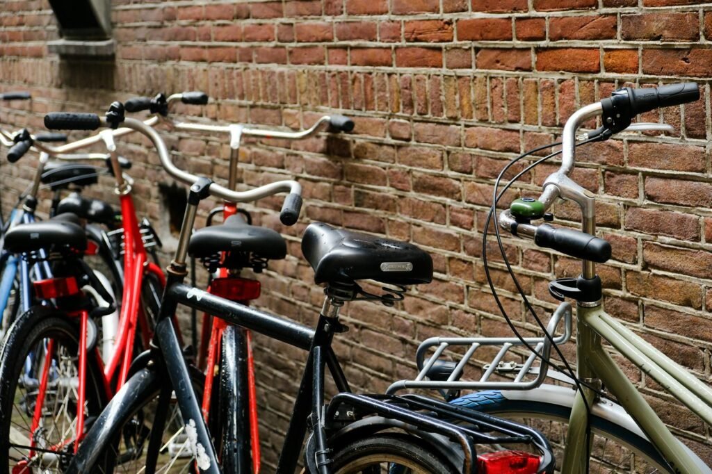 A city commuter bike with lights, rack and fenders parked near a curb.