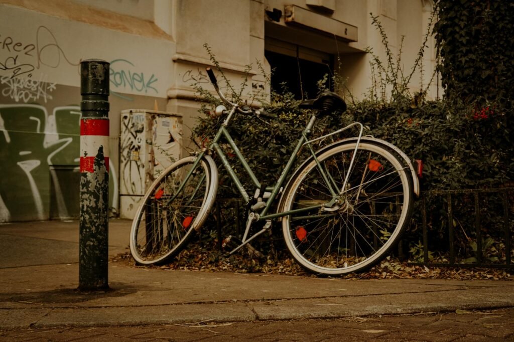 A bicycle from behind with a red rear light and reflectors visible on a dusk city street