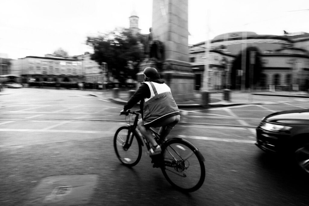 A bicycle with front and rear lights illuminated at dusk on a city street