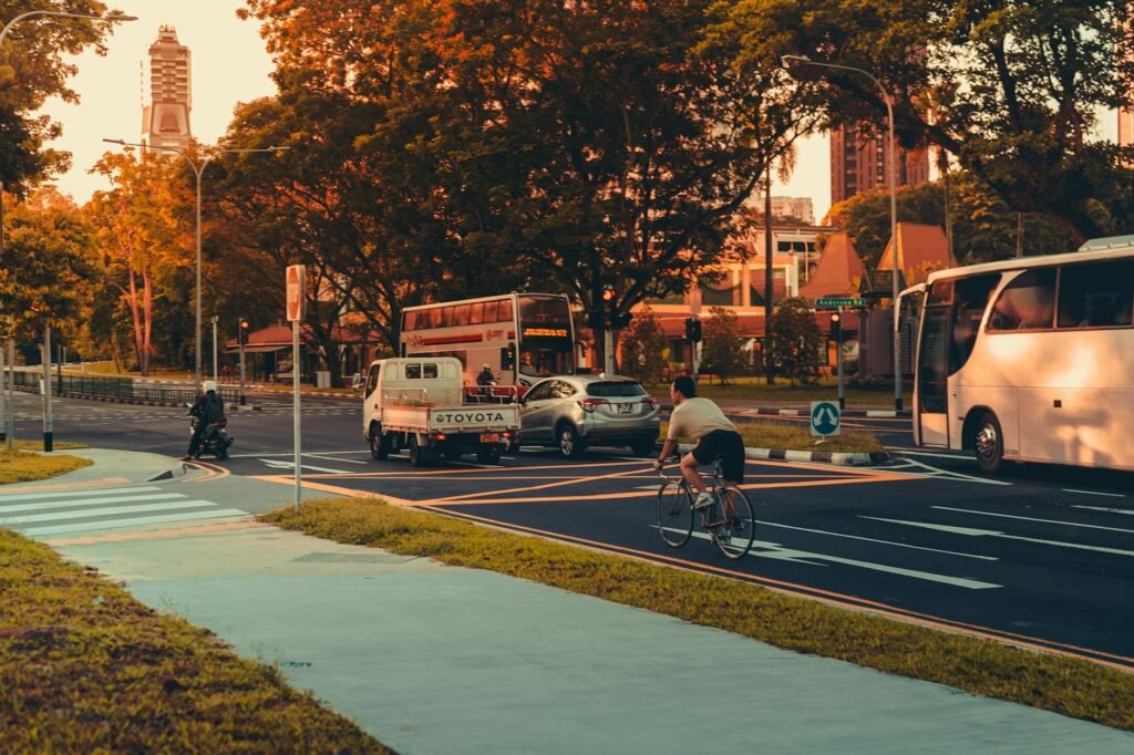 A cyclist riding in a protected bike lane during a morning city commute.