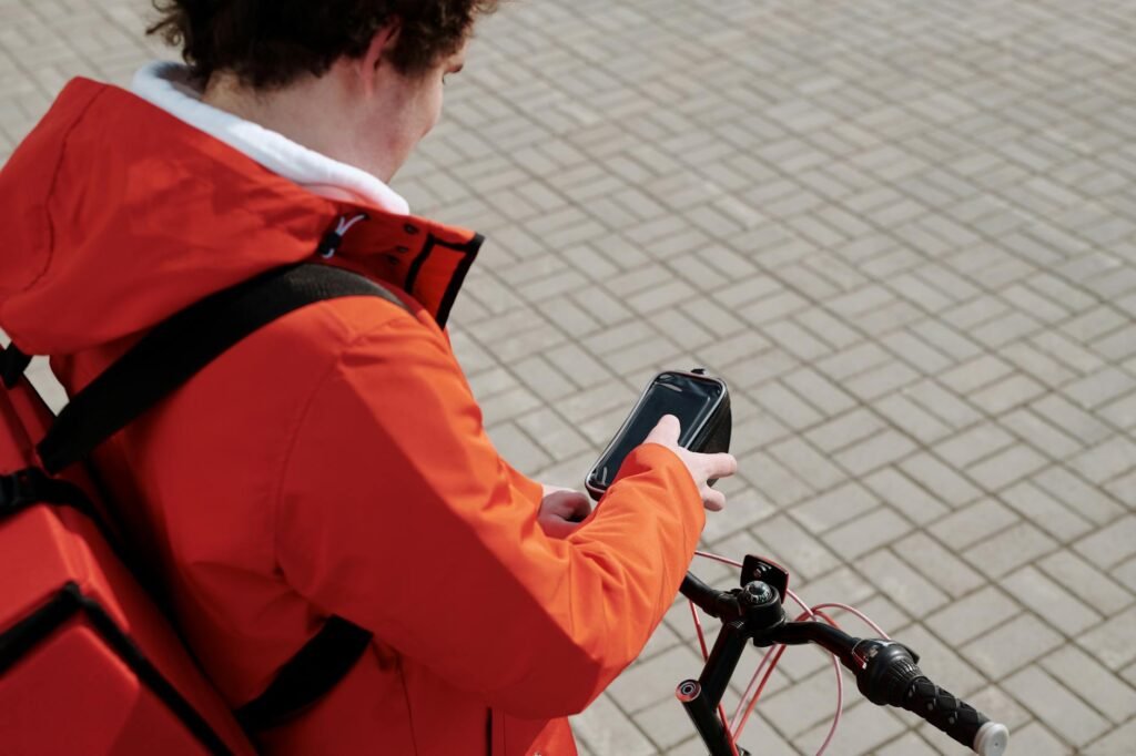 A city cyclist reviewing route options on a phone and paper map at a table