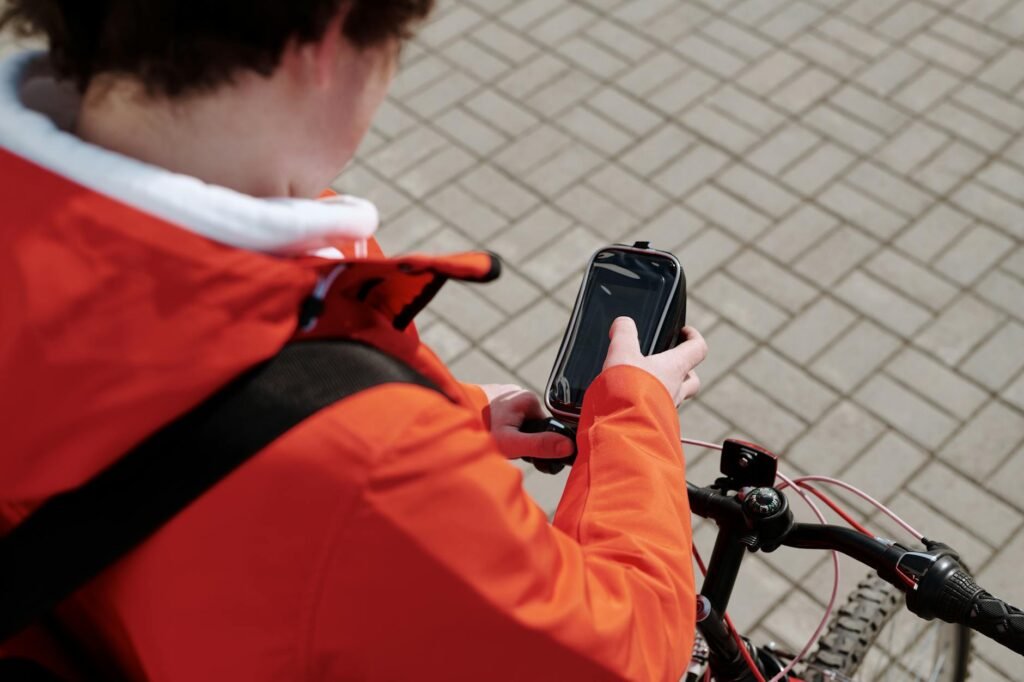A cyclist checking a route on a phone beside a bicycle before heading to work.