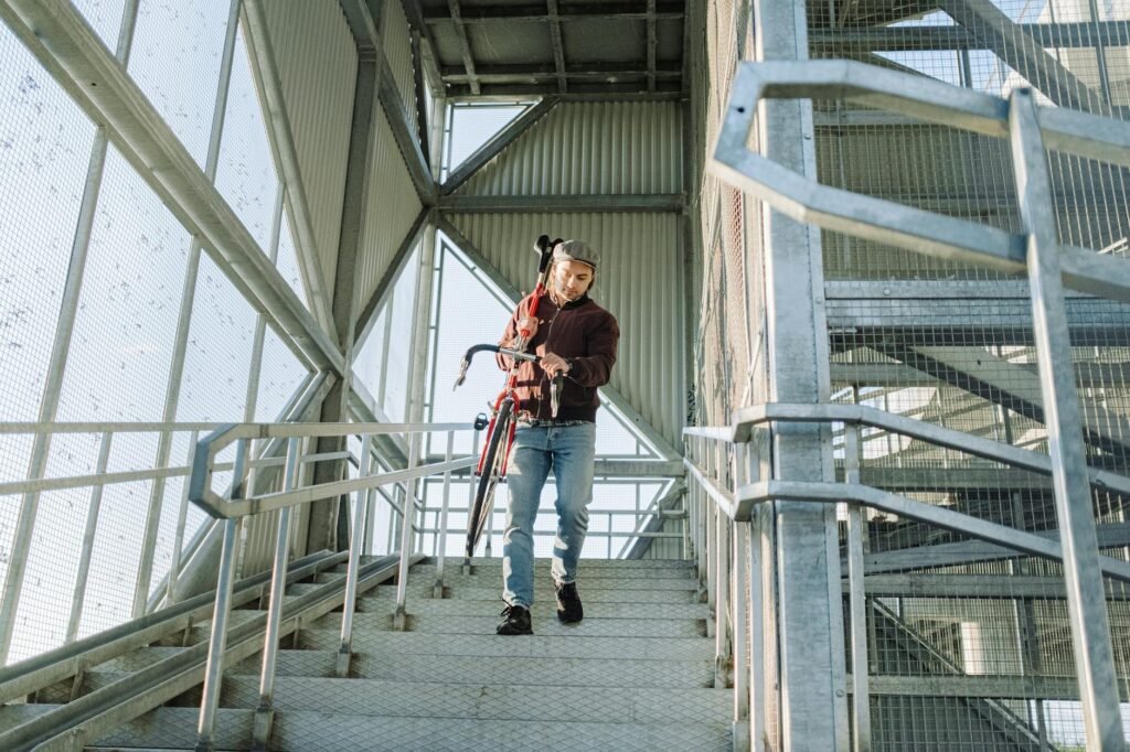 A rider carrying a commuter e-bike up apartment stairs