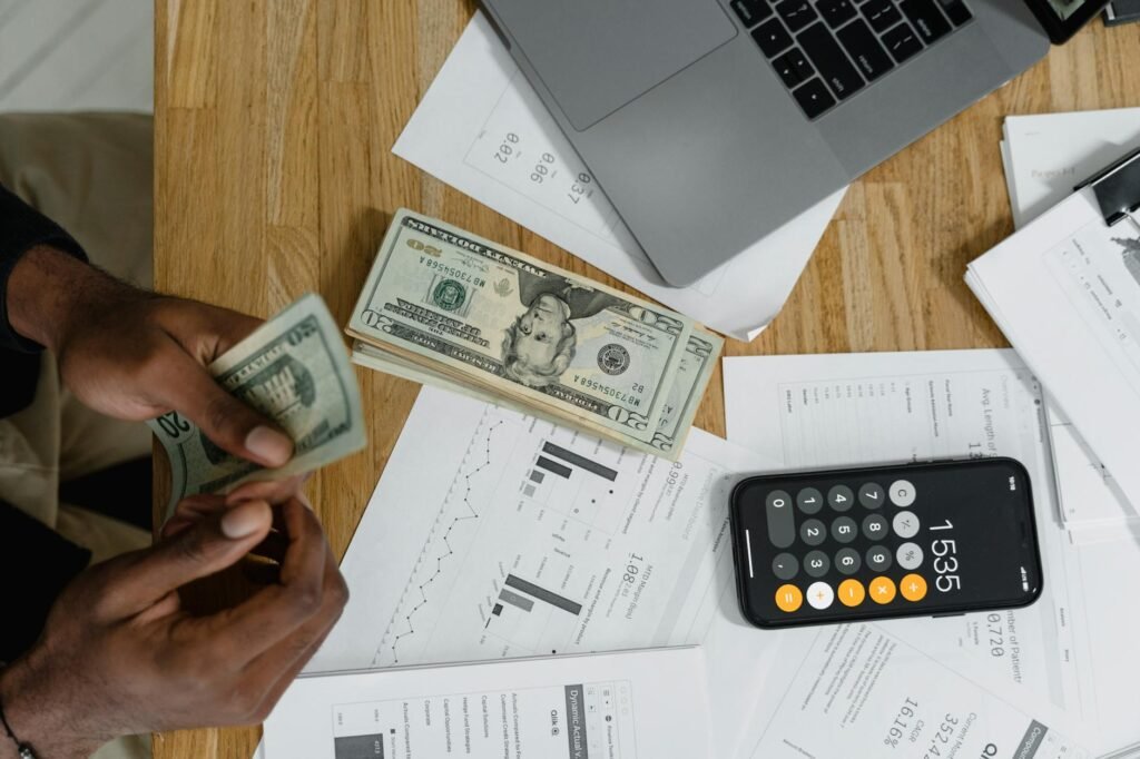 A desk with a calculator, receipts, a notebook, a bike lock, and a transit card