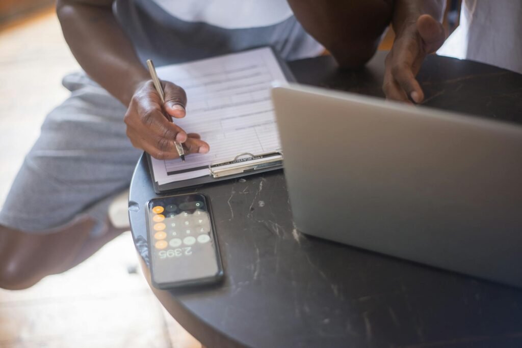 A desk with a phone map, notebook, calculator, and receipts used for planning a bike commute