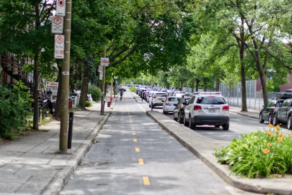 A bike lane beside a row of parallel parked cars on a city street
