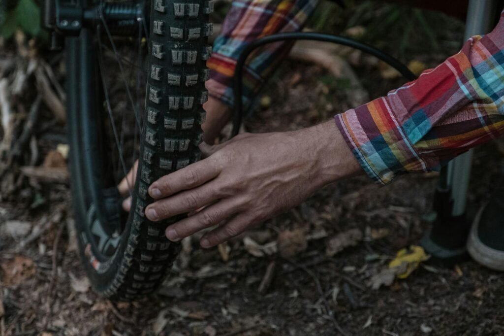 A cyclist checking commuter bike tire pressure with a floor pump gauge