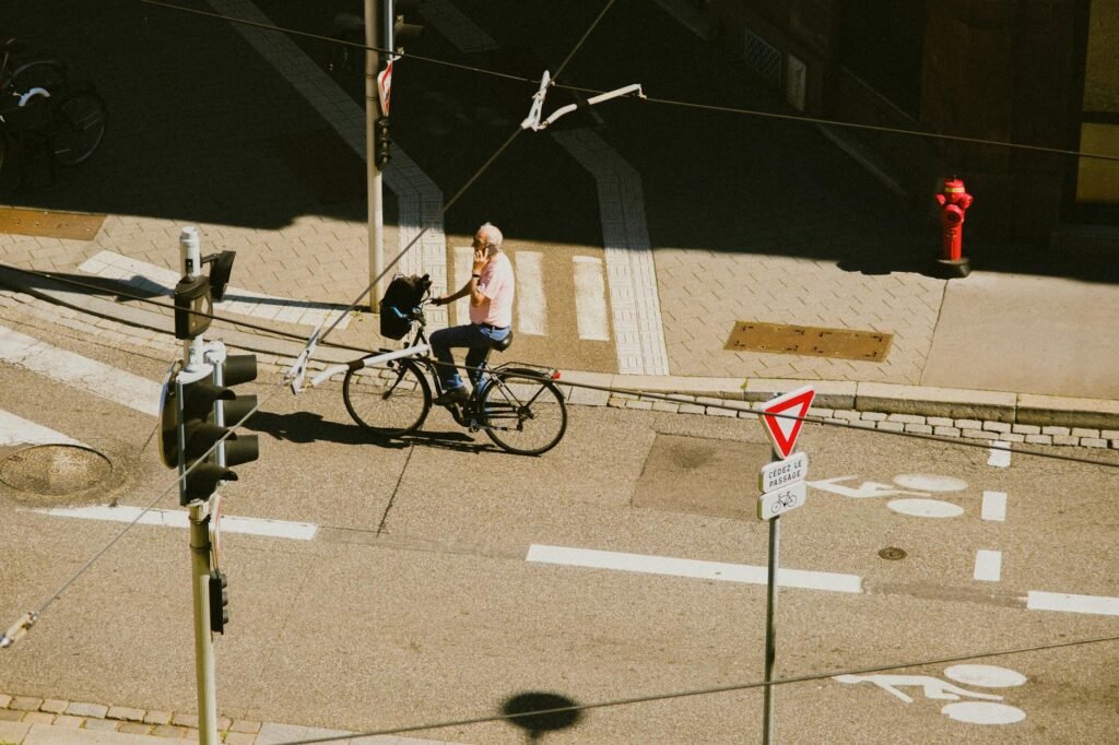 A city cyclist in everyday clothes waiting at a stoplight on a hybrid bike